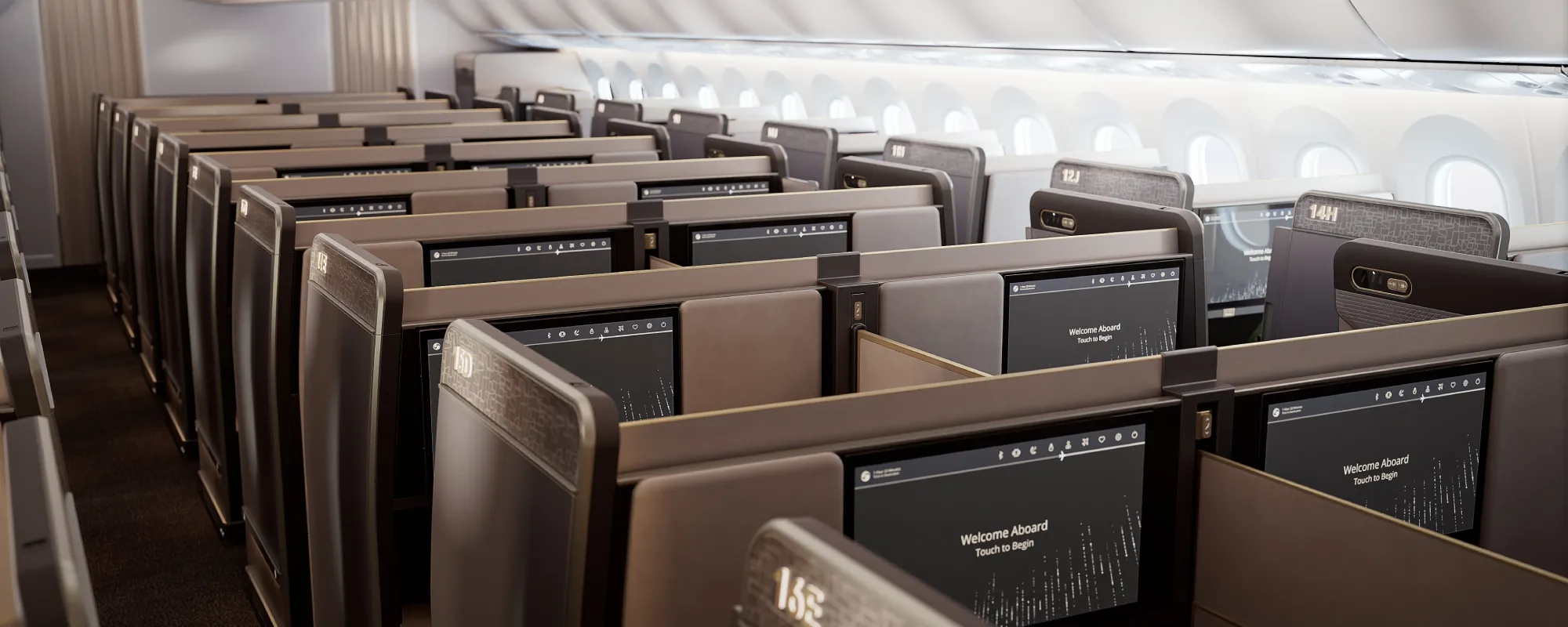 Zadní pohled do kabiny business třídy Boeing 787-10, ukazující řady sedadel Prestige Suite 2.0 s velkými obrazovkami s uvítací zprávou a diskrétním oddělením prostoru.